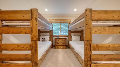 a bedroom with two bunk beds and a window at 2 Truckee Cabin • Sleeps 20 • Hot tub • Games • Near Donner Lake Donner Ridge Alplenglow Chalet by AvantStay in Truckee