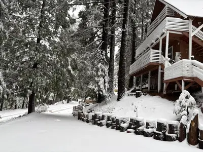 a house with snow on the ground in front of it at El Capitan Hideaway - A-Frame Cabin Yosemite West in Yosemite West