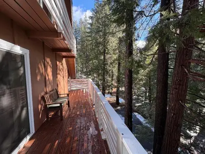 a porch of a house with a bench on it at El Capitan Hideaway - A-Frame Cabin Yosemite West in Yosemite West