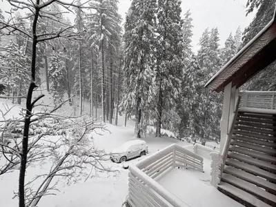 a car parked in the snow next to a house at Half Dome Haven - Cozy Yosemite West Studio in Yosemite West