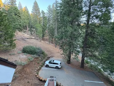 a car parked in a parking lot in the woods at Half Dome Haven - Cozy Yosemite West Studio in Yosemite West