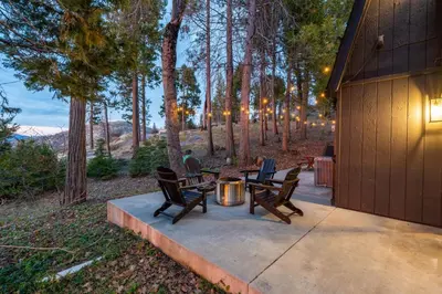 a patio with a table and chairs and trees at Dogwood Retreat- Family friendly Epic Views in Shaver Lake