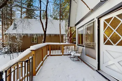 a porch covered in snow next to a house at Cabin on the Green in South Lake Tahoe