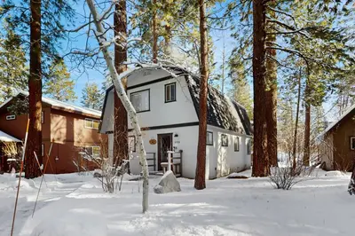 a white house in the snow with trees at Cabin on the Green in South Lake Tahoe