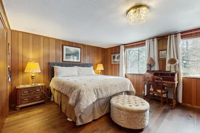 a bedroom with a bed and a desk and a chair at Cabin on the Green in South Lake Tahoe