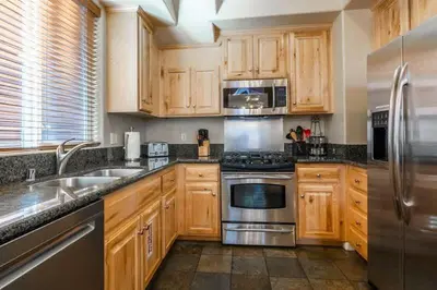 a kitchen with wooden cabinets and stainless steel appliances at Mammoth Gateway Village #3 in Mammoth Lakes