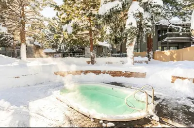 a hot tub in a snow covered yard at Sierra Park Villas 28 in Mammoth Lakes