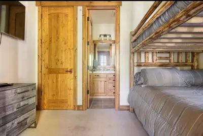 a bedroom with a bed and a bathroom with a sink at Lodges 1123 in Mammoth Lakes