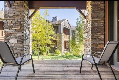 two chairs sitting on a wooden porch with a house at Lodges 1123 in Mammoth Lakes