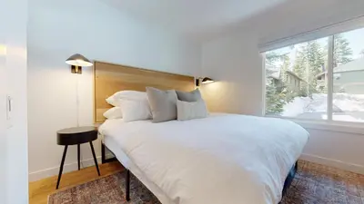 a bedroom with a large white bed with a window at Seasons Four 152 in Mammoth Lakes