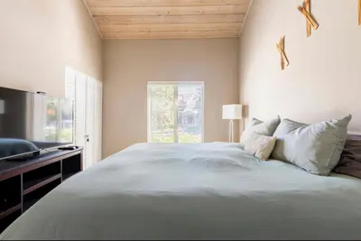 a bedroom with a large bed and a television at Snowcreek 569 in Mammoth Lakes