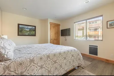 a bedroom with a bed and a television and a window at Mammoth Sierra Townhome 1 in Mammoth Lakes