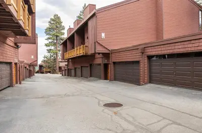 an empty driveway in front of a red brick building at Mammoth Ski and Racquet 116 in Mammoth Lakes