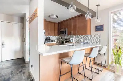 a kitchen with a white counter and stools at Mammoth Ski and Racquet 116 in Mammoth Lakes