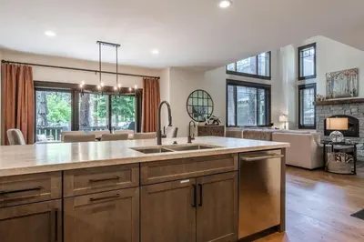 a large kitchen with a sink and a living room at Timbers 1057 in Mammoth Lakes