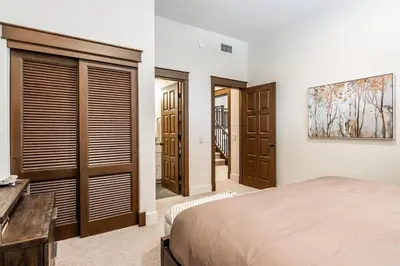 a bedroom with a bed and some wooden doors at Timbers 1057 in Mammoth Lakes