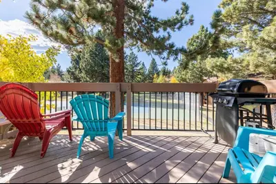a deck with two chairs and a grill on it at Villa De Los Pinos 15 in Mammoth Lakes