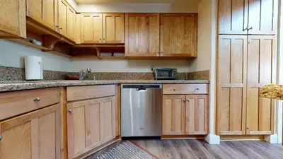 a kitchen with wooden cabinets and a dishwasher at Aspen Creek 230 in Mammoth Lakes