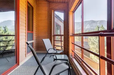 two chairs on a balcony with a view of mountains at Aspen Creek 230 in Mammoth Lakes