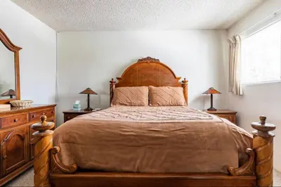 a bedroom with a large bed with a wooden headboard at Mammoth View Villas 39 in Mammoth Lakes