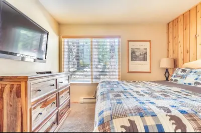 a bedroom with a bed and a flat screen tv at Viewpoint 151 in Mammoth Lakes