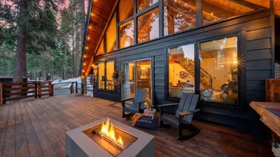 a house with a fireplace on a deck at Hot Tub • Firepit • Loft Suite Mins to World-Class Skiing Tahoe A-Frame Retreat by AvantStay in Carnelian Bay