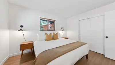 a white bedroom with a large bed and a window at Hot Tub • Firepit • Loft Suite Mins to World-Class Skiing Tahoe A-Frame Retreat by AvantStay in Carnelian Bay