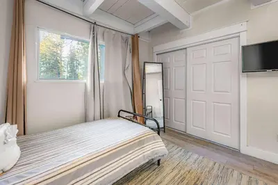 a bedroom with a bed and a sliding door at Zephyr Chalet Steps from Zephyr Cove in Glenbrook