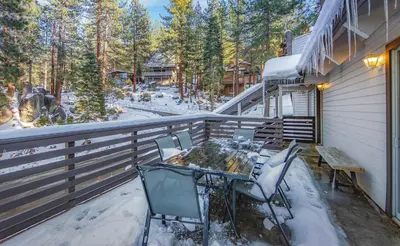 a table and chairs on a balcony with snow on it at Zephyr Chalet Steps from Zephyr Cove in Glenbrook