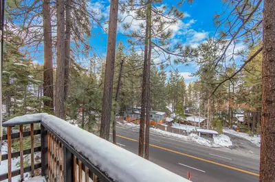 a balcony with a view of a road and trees at Zephyr Chalet Steps from Zephyr Cove in Glenbrook