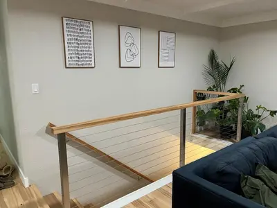 a living room with a staircase with a blue couch at Peach lane house in Newcastle