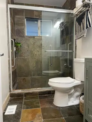 a bathroom with a toilet and a glass shower at Peach lane house in Newcastle