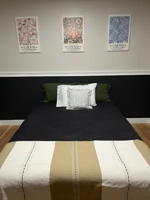 a bed with a black and white comforter in a bedroom at Peach lane house in Newcastle
