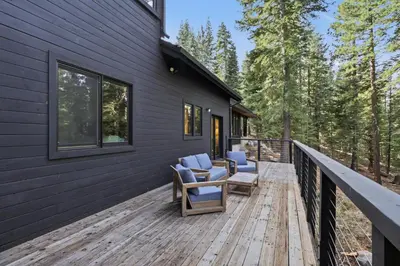 a wooden deck with chairs on the side of a house at Sierra Sanctuary with Hot Tub home in Truckee
