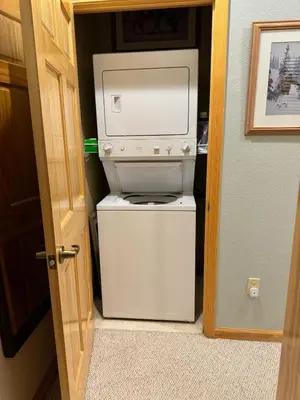 a small white refrigerator in a room with a door at Ski-in Ski-out Family Condo steps from lifts in Kirkwood