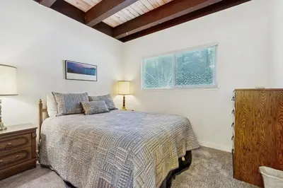 a bedroom with a bed and a dresser and two windows at Vintage Tahoe Chic at Incline Village in Incline Village