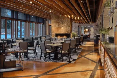 a dining room with tables and chairs and a fireplace at Ritz-Carlton Northstar Luxury Ski-In Ski-Out in Truckee
