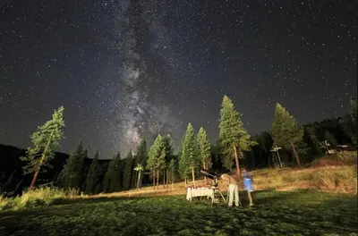 two people standing in a field under a starry sky at Ritz-Carlton Northstar Luxury Ski-In Ski-Out in Truckee