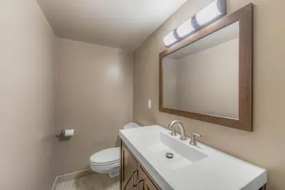 a bathroom with a sink and a toilet and a mirror at Bavarian Village Escape For 6 in South Lake Tahoe