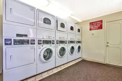 a row of white washing machines in a laundry room at Bavarian Village Escape For 6 in South Lake Tahoe