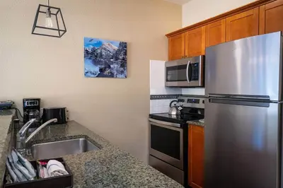a kitchen with a stainless steel refrigerator and a sink at Top Floor Village Ski-In/Ski-Out Condo in Olympic Valley