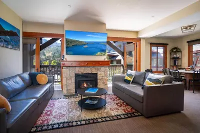 a living room with a couch and a fireplace at 3BR Condo in Village at Palisades - Premier in Olympic Valley