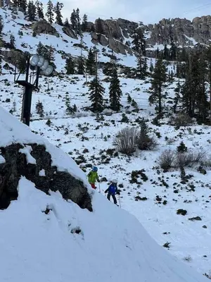 two people are skiing down a snow covered mountain at 3BR Condo in Village at Palisades - Premier in Olympic Valley