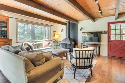 a living room with a couch and a red door at The Green Hideaway Arnold Cabin in the Pines! in Arnold