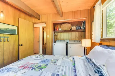 a bedroom with a bed and a washer and dryer at The Green Hideaway Arnold Cabin in the Pines! in Arnold