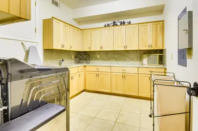 a kitchen with wooden cabinets and a dishwasher at Peaceful Escape in the Pines Arnold Cabin with Deck in Arnold