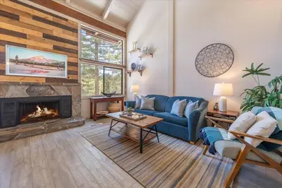 a living room with a blue couch and a fireplace at Northstar Nest in Truckee