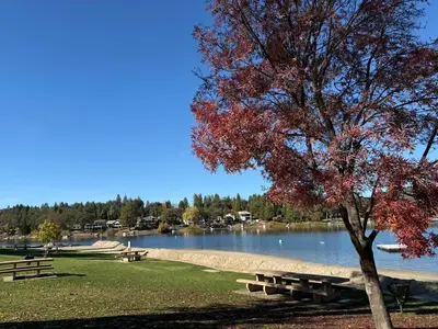 a park with picnic tables next to a lake at StayCation Sierra – Nonpareil Retreat in Groveland