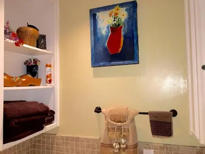 a bathroom with a painting of a red vase on the wall at Beautiful house by the river and the villager in Fair Oaks