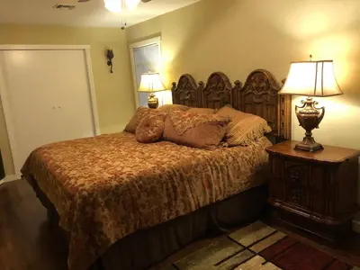 a teddy bear laying on a bed in a bedroom at The village Inn in Fair Oaks